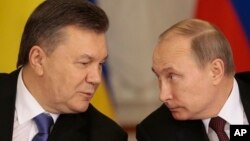 Presiden Rusia Vladimir Putin (kanan) dan Presiden Ukraina Viktor Yanukovych berbicara di sela-sela konferensi pers di Moskow, Selasa (17/12).
