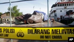 The recovered wreckage of the ill-fated AirAsia Flight 8501 that crashed in the Java Sea are covered by tarps at Kumai port in Pangkalan Bun, Indonesia, Jan. 12, 2015.