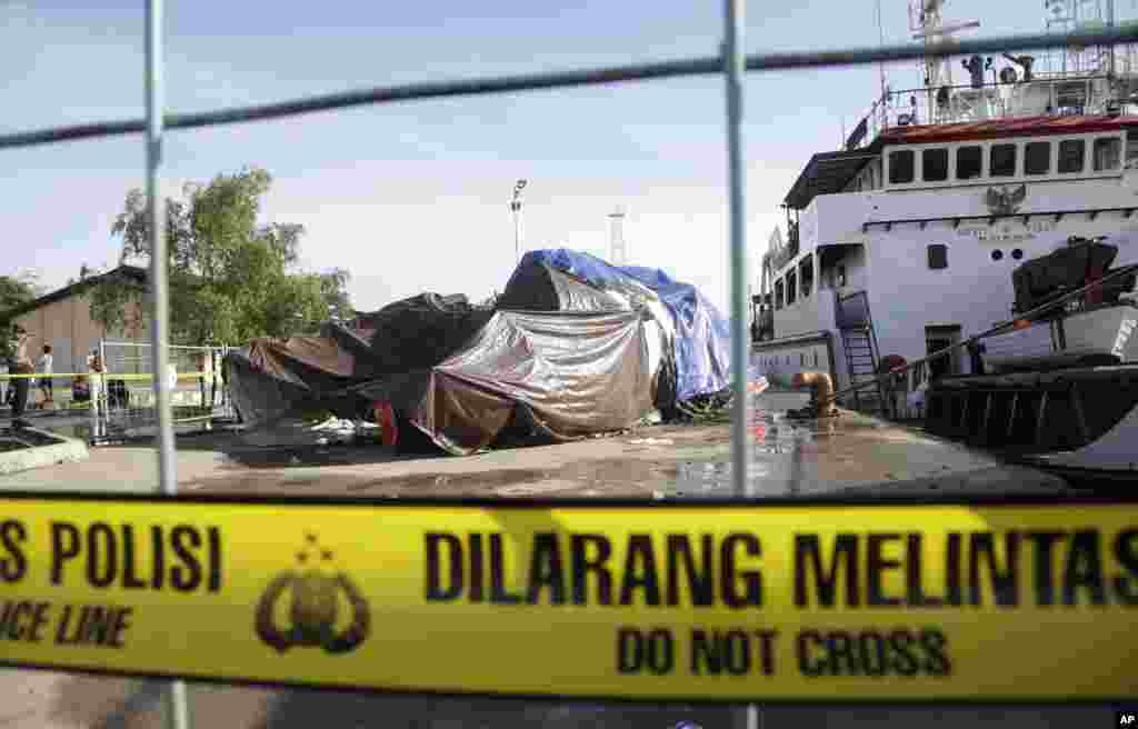 The recovered wreckage of the ill-fated AirAsia Flight 8501 that crashed in the Java Sea are covered by tarps at Kumai port in Pangkalan Bun, Indonesia, Monday, Jan. 12, 2015.