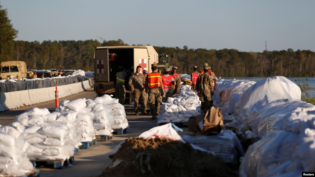 Miembros de la Guardia Nacional construyen una barrera de bolsas de arena para evitar inundaciones a causa del huracÃ¡n Florence en la ruta US 501 en Carolina del Sur el miÃ©rcoles, 19 de septiembre de 2018.