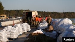 Miembros de la Guardia Nacional construyen una barrera de bolsas de arena para evitar inundaciones a causa del huracán Florence en la ruta US 501 en Carolina del Sur el miércoles, 19 de septiembre de 2018.