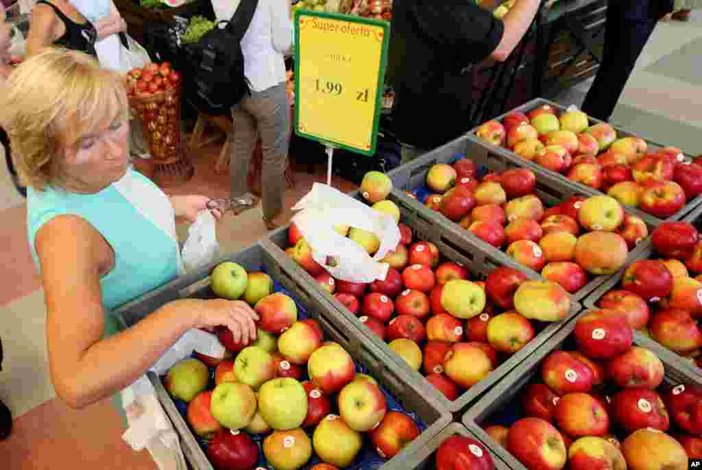 Fruit farmers marched in Warsaw to encourage Poles to eat more apples to offset the expected negative effects of a ban that Russia imposed last week on Polish fruit. In this photo, a woman is picking apples to buy at 1.99 zlotys (euro 0.47) per kilo at a supermarket in Warsaw, Poland, Aug. 6, 2014.