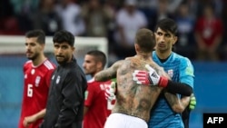 L'espagnol Sergio Ramos, au centre, embrasse le gardien iranien Ali Beiranvand à la fin du match du groupe B entre l'Iran et l'Espagne à la Coupe du monde de football 2018 dans l'aréna de Kazan, Russie, 20 juin 2018.