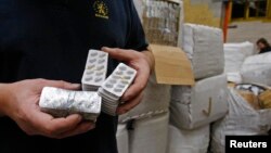 FILE - A Belgian customs officer shows tablets of counterfeit drugs at Brussels' Airport on October 3, 2008. The fake medicine was seized en route from India to Togo.