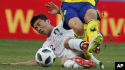 Lee Yong, de Corea del Sur, comete una falta sancionada como penal sobre Viktor Claesson, de Suecia, en el partido del Mundial realizado el lunes 18 de junio de 2018, en Nizhny Novgorod, Rusia