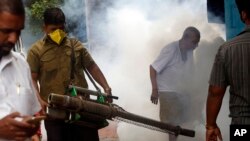 A municipal worker fumigates an area outside a train station to check the spread of mosquito-borne diseases in Mumbai, India, Sept. 3, 2016. 