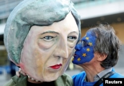 An anti-Brexit demonstrator kisses a protester dressed as Britain's Prime Minister Theresa May ahead of a EU Summit in Brussels, Belgium, March 21, 2019.