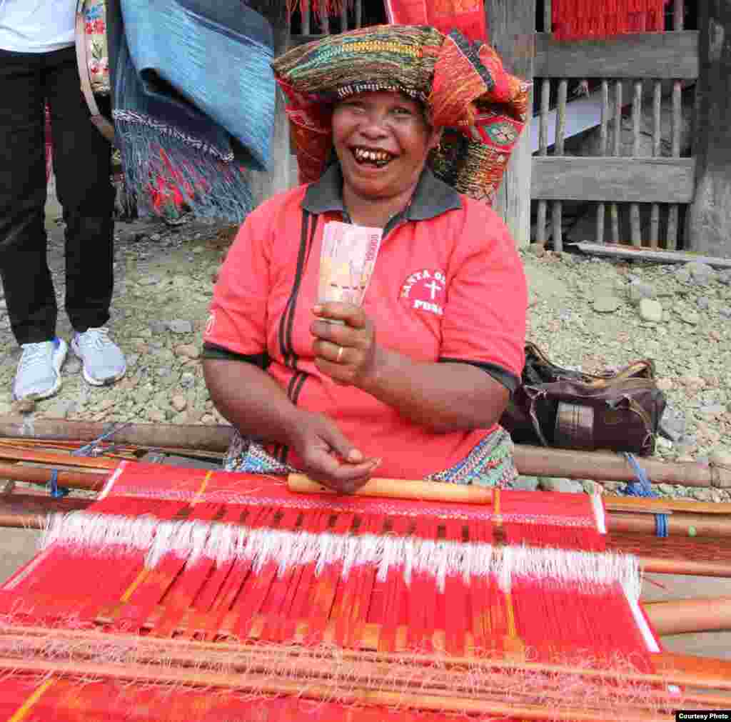 Seorang perempuan pengrajin tenun Ulos Batak di Sumatera Utara, hari Jumat (8/3) sangat gembira ketika ulos tenunannya laku. (Courtesy: Maruli Sinambela/ Vibiz Media)