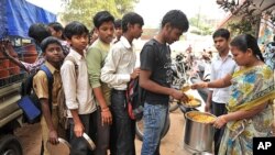 FILE - An Indian teacher serves the mid-day meal to children at a Government High School in Hyderabad.
