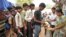 FILE - An Indian teacher serves the mid-day meal to children at a Government High School in Hyderabad.