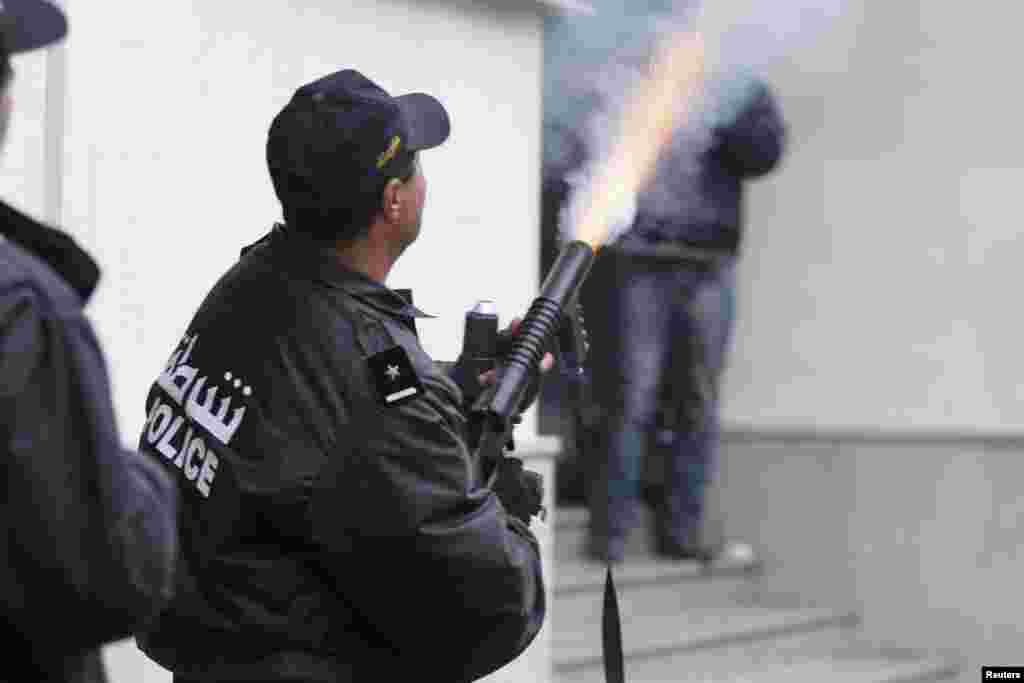 A police officer fires teargas to break up a protest in Tunis, Feb. 6, 2013. 