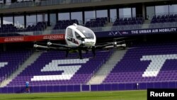 People attend a test flight for Ehang 216, a two-seater autonomous aerial vehicle of drone maker EHang in Vienna, Austria, April 4, 2019. 