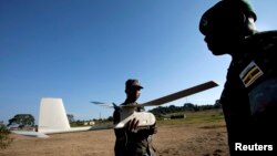 Ugandan military personnel work with a small U.S.-made drone the Ugandan military uses in Somalia to fight al-Qaida linked militants, at a demonstration and briefing at Kasenyi Military Base in Kampala, Aug. 3, 2012.
