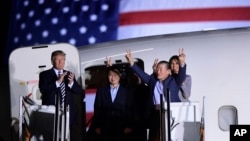 President Donald Trump, from left, greets Tony Kim, Kim Hak Song, seen in the shadow, and Kim Dong Chul, three Americans detained in North Korea for more than a year, as they arrive at Andrews Air Force Base in Md., May 10, 2018. First lady Melania Trump also greets them at right. 