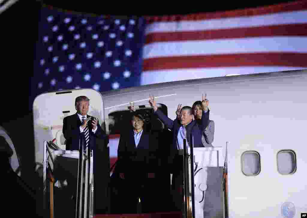 President Donald Trump, from left, greets Tony Kim, Kim Hak Song, seen in shadow, and Kim Dong Chul, three Americans detained in North Korea, as they arrive at Andrews Air Force Base in Md., May 10, 2018. First lady Melania Trump also was there to greet them.