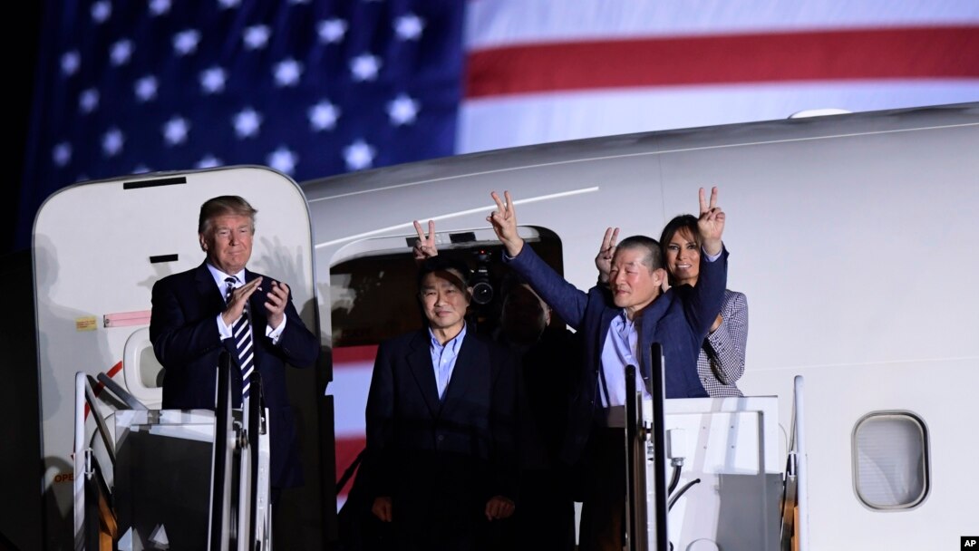 Predsednik Donald Tramp (s leva) pozdravlja Tonija Kima, Haka Songa, koji se vidi u senci, i Kim Dong Čula, trojicu Amerikanaca koji su bili zatvoreni u Severnoj Koreji više od godinu dana, nakon što su sleteli u vojnu bazu Endrjuz, 10. maja 2018. Desno je prva dama, Melanija Tramp.