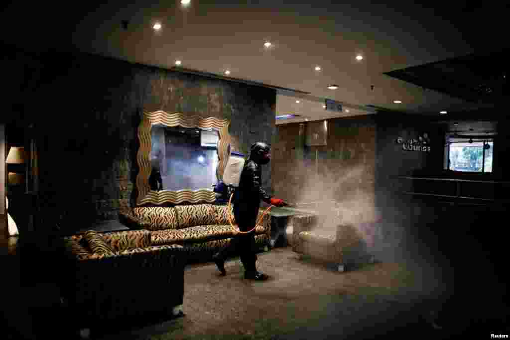 A worker disinfects the lobby of the hotel Alba Caracas which is being readied to become a hospital for patients suffering from the COVID-19 in Caracas, Venezuela, April 7, 2021.