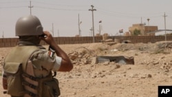 An Iraqi soldier monitors the Iraq-Syria border point, Abu Kamal, July 22, 2012.