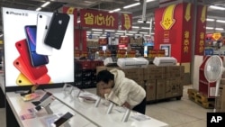A man browses an iPhone unit on display at a market in Beijing, Thursday, May 9, 2019.