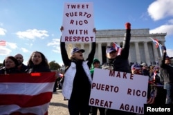 Protesters hold up signs to highlight the ongoing humanitarian and natural disaster crisis in Puerto Rico, at the Lincoln Memorial in Washington, Nov. 19, 2017.