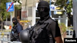 FILE - Kosovo police officers stand guard outside a Pristina courthouse in 2014 following the arrest of 40 men suspected of having fought with Islamist insurgents in Syria and Iraq.