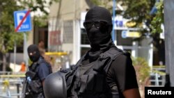 FILE - Kosovo police officers stand guard outside a Pristina courthouse in 2014 following the arrest of 40 men suspected of having fought with Islamist insurgents in Syria and Iraq.