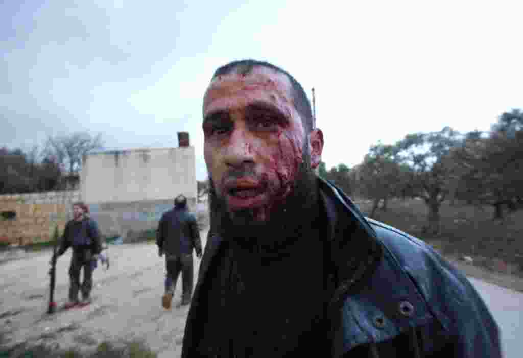 Seorang pemberontak yang terluka bergerak mundur untuk mendapatkan perawatan medis di Idlib, 8 Februari (AP).