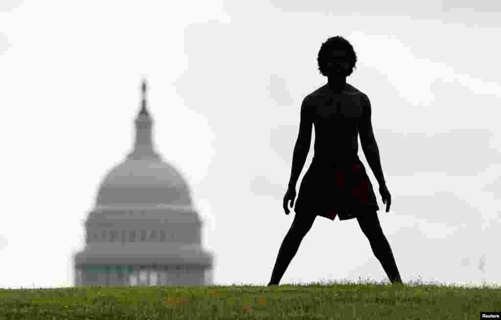 With the dome of the U.S. Capitol in the background, a homeless man named Damu stretches on the National Mall in Washington.