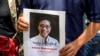 A protester holds a portrait of allegedly kidnaped Thai activist Wanchalearm Satsaksit outside the Embassy of Cambodia in Bangkok on June 8, 2020. - Wanchalearm Satsaksit, a critic of the ex-general Prayut Chan-O-Cha's Thai government, was dragged…