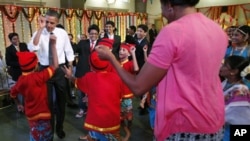 President Barack Obama and first lady Michelle Obama dance with students as they celebrate Diwali, a revered festival, during a visit to Holy Name High School in Mumbai, India, Sunday, Nov. 7, 2010. (AP Photo/Charles Dharapak)