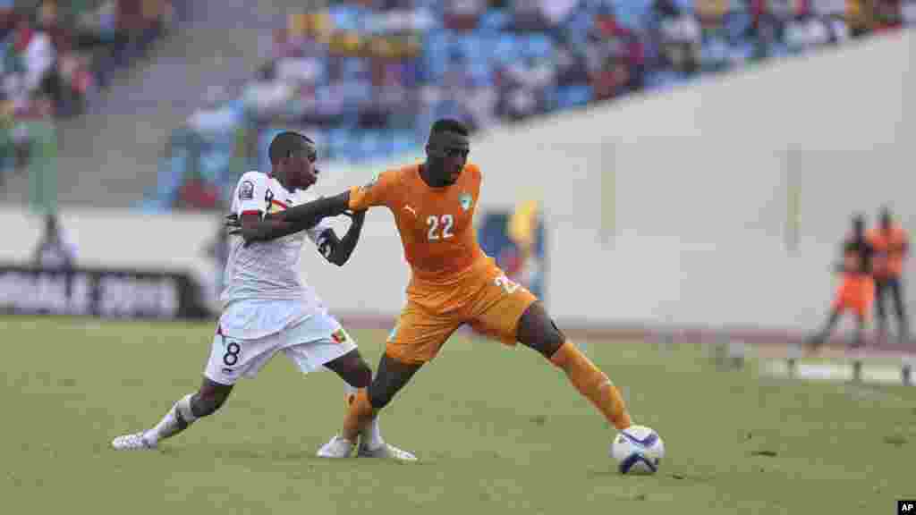 Serge Wilfriedde la Côte-d'Ivoire, à droite, est abordé par Ibrahima Traoré de la Guinée au cours de du match du groupe D de la CAN entre leurs équipes au stade de Malabo, Guinée équatoriale, mardi 20 janvier 2015.
