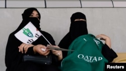 FILE - Saudi women watch the soccer match between Al-Ahli against Al-Batin at the King Abdullah Sports City in Jeddah, Saudi Arabia, Jan. 12, 2018.