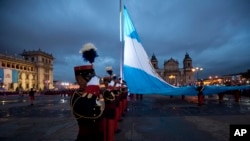 Soldados guatemaltecos vuelan la bandera nacional en la Plaza de la Constitución en la ciudad de Guatemala. Foto de archivo.