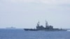 FILE - A Taiwanese navy ship, foreground, monitors a Chinese aircraft carrier, background, near Taiwanese waters in September 2023, in this photo released by the Taiwan Ministry of National Defense.