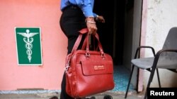 FILE - A representative for drugmaker Abbott enters a doctor's clinic in Pune, Aug. 27, 2012.