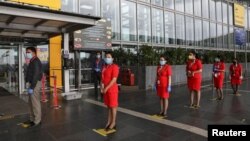 Air Asia staff members stand on social distancing markings, as they wait to enter Netaji Subhas Chandra Bose International Airport (CCU), after the government allowed domestic flight services to resume, during an extended nationwide lockdown to slow the spread of the coronavirus.