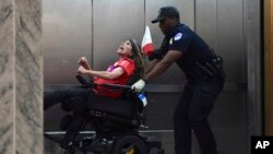 Una manifestante contra la propuesta de ley de atención médica que planean los legisladores republicanos es desalojada del Congreso de EE.UU. Sept. 25 de 2017. 