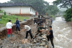 지난 2007년 8월 북한 황해북도 신평군에서 주민들이 폭우와 홍수로 부서진 하천 제방을 보수하고 있다. (자료사진)