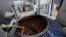 FILE - A worker stands beside a container of roasted coffee beans in a factory in Havana, Cuba, April 7, 2011. 