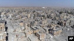 FILE - This Oct. 19, 2017 frame grab made from drone video shows damaged buildings in Raqqa, Syria.