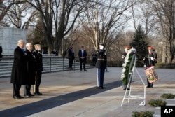 President-elect Donald Trump, accompanied by Vice President-elect Mike Pence pauses after placing a wreath at the Tomb of the Unknowns on Jan. 19, 2017, one day before his presidential inauguration.