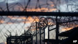 FILE - Dawn arrives at the now-closed Camp X-Ray, which was used as the first detention facility for al-Qaida and Taliban militants who were captured after the Sept. 11 attacks, at the Guantanamo Bay Naval Base, Cuba. 