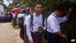 Swe Win, second right, an editor of the nonprofit online news outlet Myanmar Now, waits with other journalists for trial of The Voice editor Kyaw Min Swe outside a township court in Yangon, Myanmar, June 23, 2017.