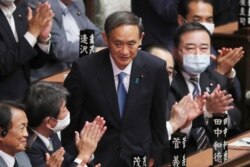 Yoshihide Suga is applauded after being elected as Japan's new prime minister at parliament's lower house in Tokyo, Sept. 16, 2020.