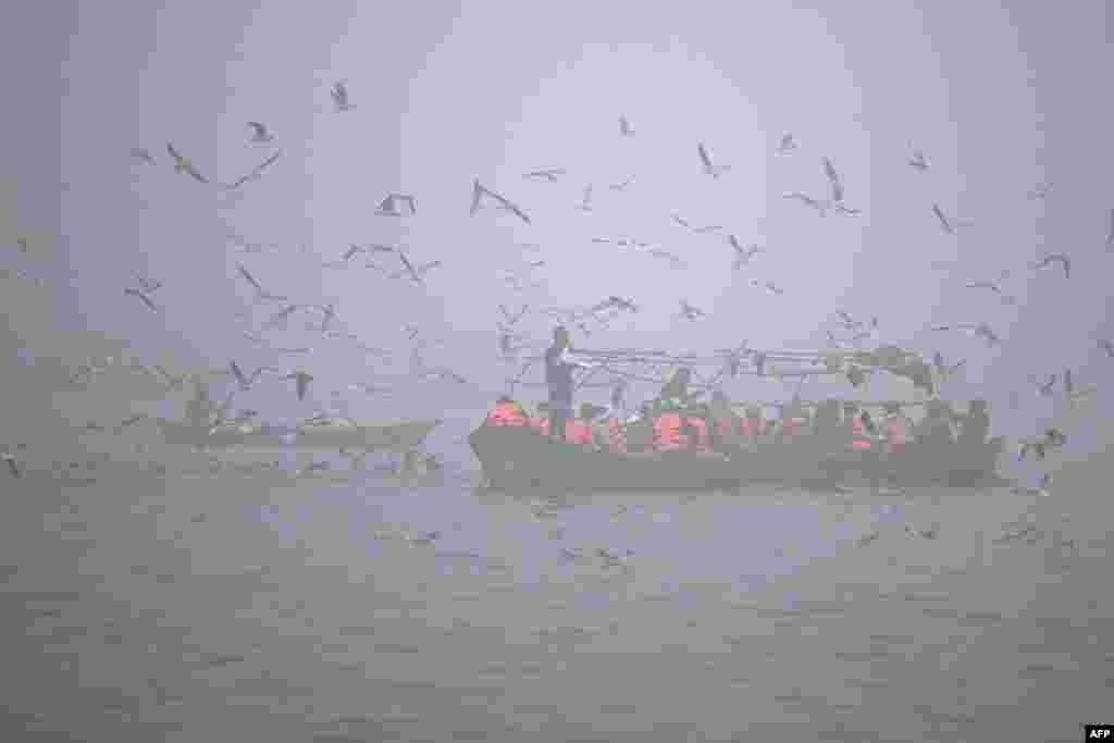 Rescue personnel ferry a boat for security measures, at Sangam, the confluence of Ganges, Yamuna and mythical Saraswati rivers, during the Maha Kumbh Mela festival in Prayagraj on Jan. 13, 2025.