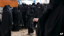 FILE - Women line up for aid supplies at al-Hol camp in Hassakeh province, Syria, March 31, 2019.