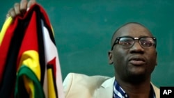 FILE - Zimbabwean Pastor Evan Mawarire holds his country's flag before addressing supporters at the University of the Witwatersrand in Johannesburg, South Africa, July 28, 2016.