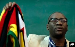 FILE - Zimbabwean Pastor Evan Mawarire holds his country's flag before addressing supporters at the University of the Witwatersrand in Johannesburg, South Africa, July 28, 2016.