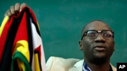 FILE - Zimbabwean Pastor Evan Mawarire holds his country's flag before addressing supporters at the University of the Witwatersrand in Johannesburg, South Africa, July 28, 2016.