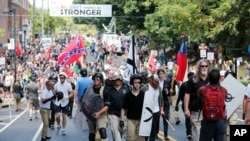 White nationalist demonstrators walk through town after their rally was declared illegal near Lee Park in Charlottesville, Va., Aug. 12, 2017.